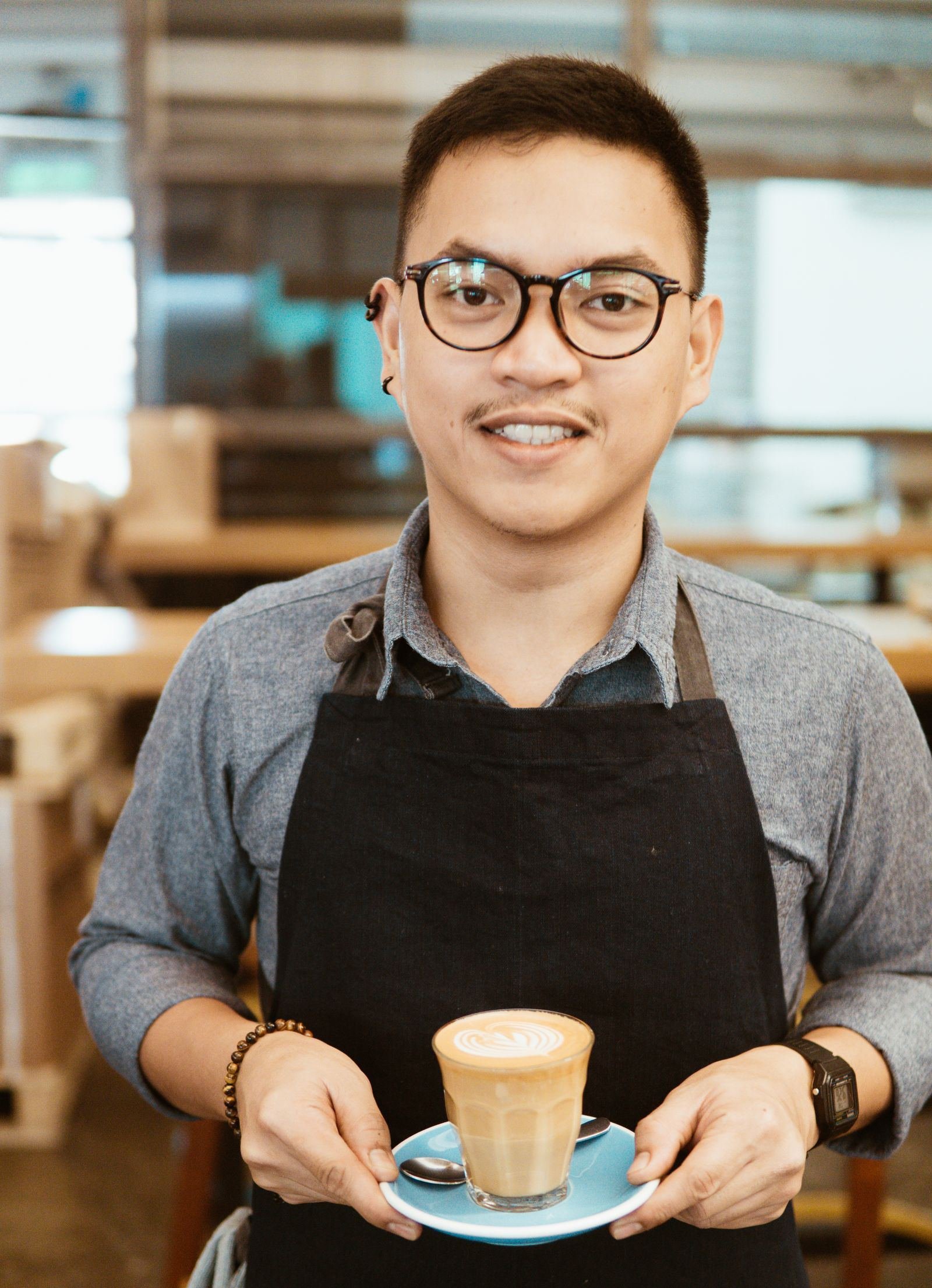 Smiling barista holding a cappuccino