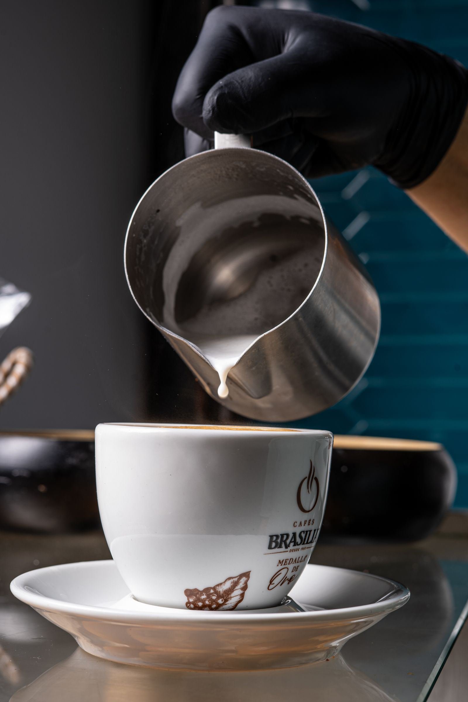 Barista pouring steamed milk into a latte
